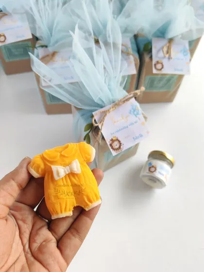 A custom gift box for a half-birthday celebration, featuring a baby onesie wax sachet and a mini jar candle, all designed around a baby lion theme.