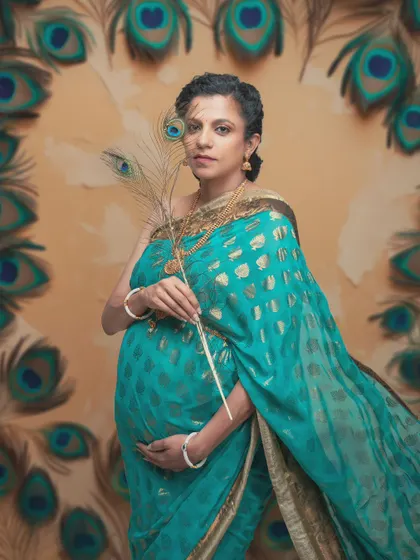 Embracing tradition, capturing eternity. This portrait honors the grace of motherhood through the symbol of the peacock feather and a beautiful turquoise saree.