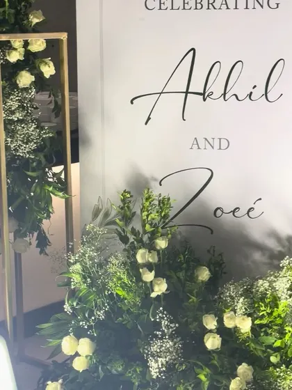 Another detail shot of the welcome sign and its surrounding floral arrangements. The combination of white flowers and lush greenery is a classic choice that never goes out of style.