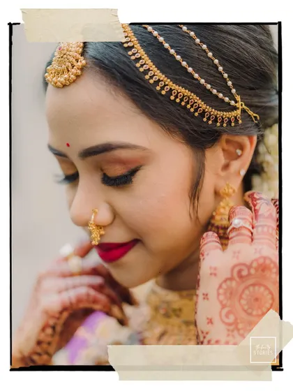 A delicate close-up of the bride, her eyes closed, highlighting her intricate matha patti and henna design.