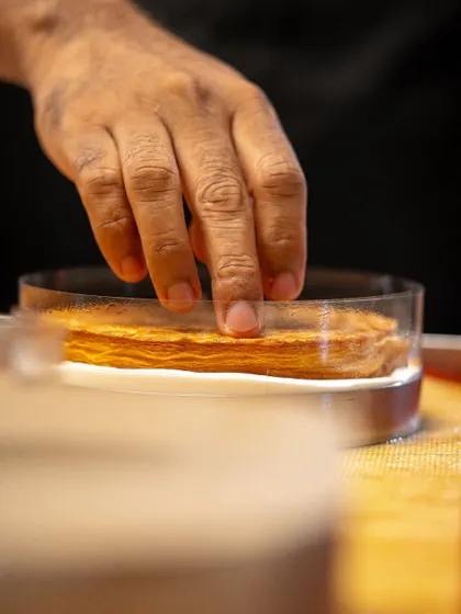 Assembling a dessert with layers of puff pastry. Our classes cover a wide range of pastry doughs and their applications.