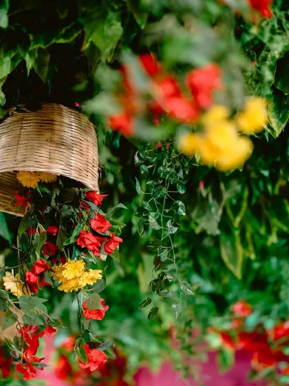 A creative decor detail with flowers spilling out of a hanging wicker basket, adding to the enchanted garden feel.