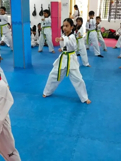 A class of green belts practicing their punches and stances.