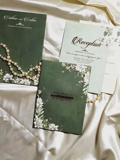 Elevate your wedding invitations without breaking the bank. This olive green invitation with floral details and two inserts is currently available at a discounted rate.