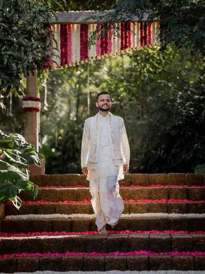 The groom's grand entrance, walking down the flower-strewn steps. We capture the anticipation and excitement of this key moment.