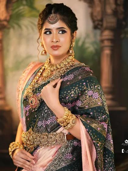 A classic pose showing the rich detail of the saree and antique jewelry, with makeup designed to last through a long day of ceremonies.