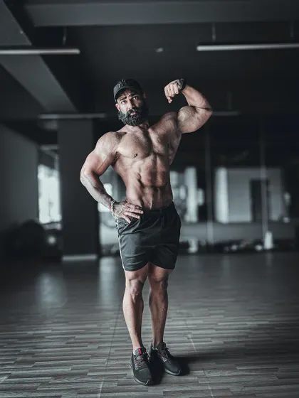 A classic one-arm bicep pose, showcasing the peak of the bicep and the serratus muscles. This is a pose that exudes confidence.
