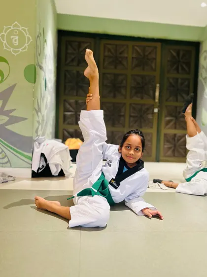 A student shows off her impressive flexibility with a standing split.