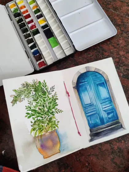 A watercolor sketch of a potted plant next to a beautiful blue door. This is from my travel sketchbook, where I capture interesting architectural details and scenes.