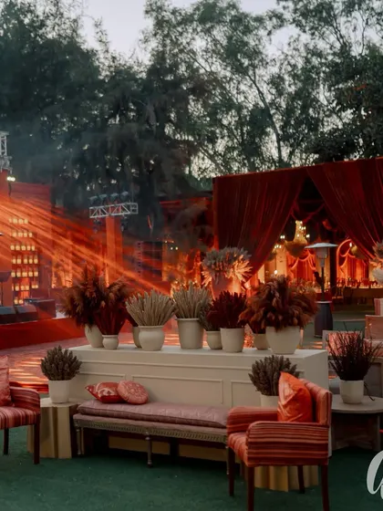 This outdoor lounge area was designed with warm red and orange tones. We used dried grasses and floral arrangements to define the space, set against a backdrop of dramatic stage lighting for the evening's performances.