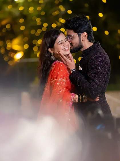 An intimate moment between Vivek and Shraddha during their evening portrait session. I love using ambient light, like these background bokeh lights, to create a dreamy, romantic atmosphere for candid couple photos.
