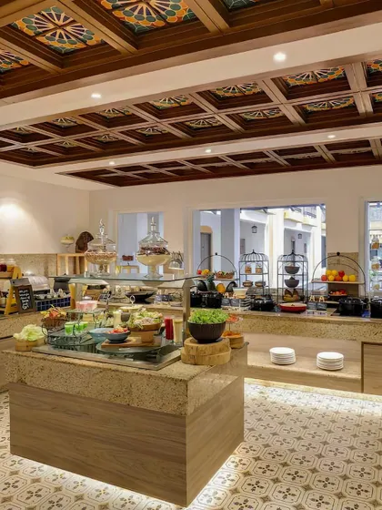 The buffet area at Lemontree Amarante Beach Resort, Goa. The design features colorful, hand-painted ceiling tiles and patterned floor tiles, infusing the space with a vibrant, local Portuguese-Goan flavor.