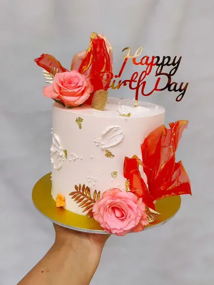 A similar design in white and red, this cake features pink roses and red sails, showing how the same concept can be customized.