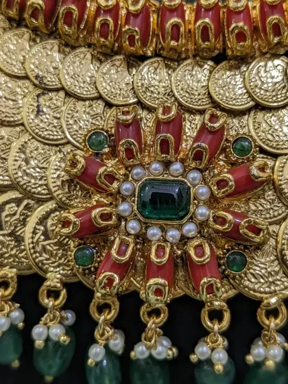 A detailed shot of the floral-coral motif on the kaasu necklace.