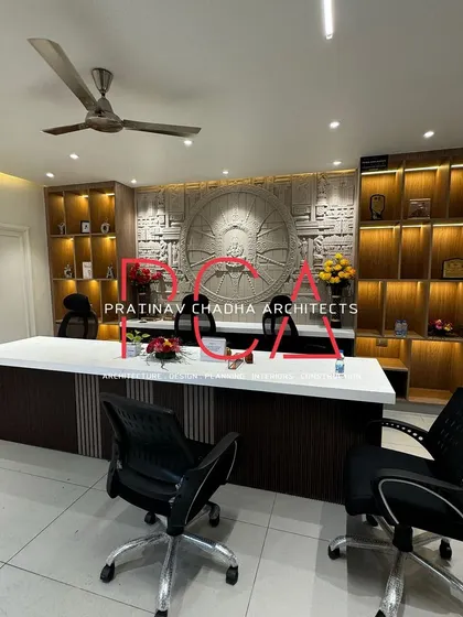 A wide shot of the completed Hari Mandir office, showcasing the main desk, custom CNC-carved wall art, and illuminated display shelves.