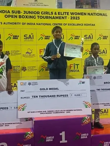 Victory at the Khelo India Sub-Junior Girls & Elite Women National Open Boxing Tournament. My student stands on the first place podium with her gold medal, certificate, and prize money.