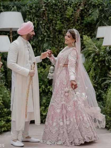 The couple shares a dance during their portrait session, showcasing the bride's stunning pastel pink lehenga.