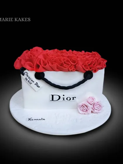 It's not just a bag, it's a Dior cake! This sculpted Black Forest cake is designed to look like a classic Dior shopping bag, complete with a cascade of red buttercream ruffles.