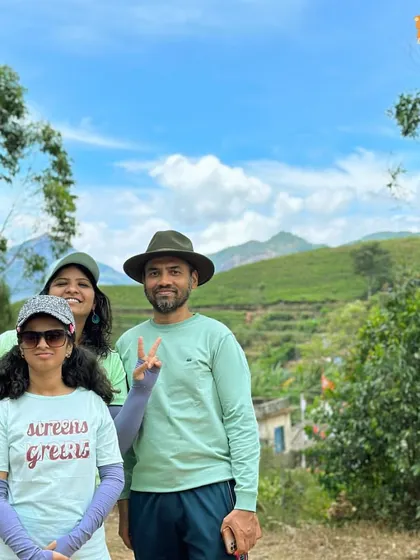 A family enjoying the green landscapes of Munnar. Our trips are designed for all ages.