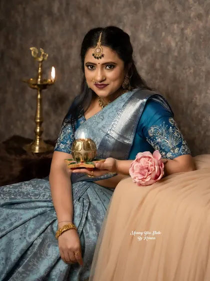A festive shot for Diwali. The entire look, from the saree and blouse to the traditional lamp, creates a beautiful and warm festive feeling.