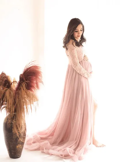 A graceful solo portrait. The side slit on the pink gown and the pampas grass prop add a modern, boho-chic element to the shot.