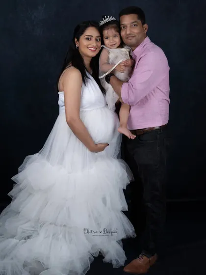 A princess and her queen. This beautiful family portrait shows the mom-to-be with her partner and their adorable daughter.