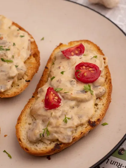 A close-up shot of our creamy mushroom toast, focusing on the texture of the sauce and the fresh cherry tomato garnish. This detail shot highlights the quality of the ingredients.