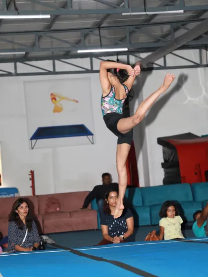 This gymnast demonstrates remarkable balance and flexibility, holding a difficult pose for an appreciative audience during our in-house event.