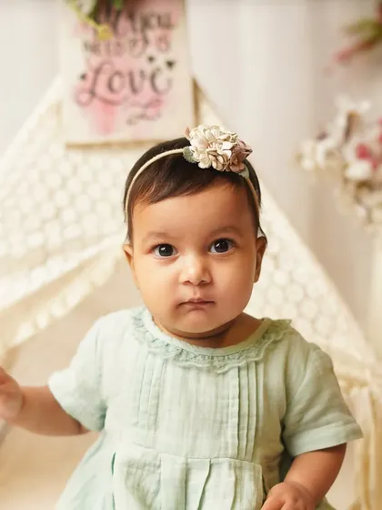 A beautiful, direct portrait of the baby girl in her boho-themed setup. Her serious expression shows a different, equally adorable side of her personality.