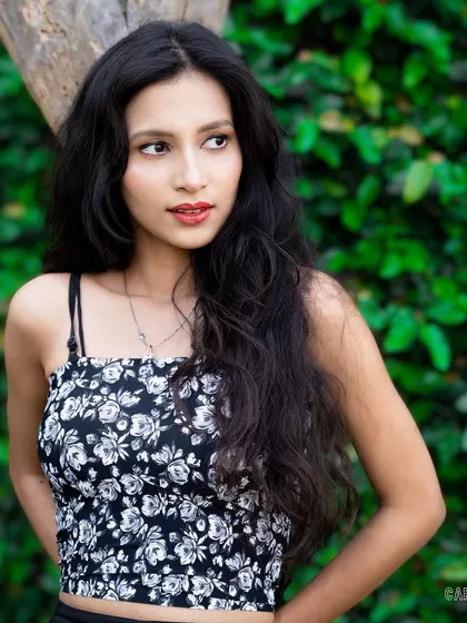 This outdoor portrait uses a natural green background to complement the model's look. The soft lighting and relaxed pose make it a great addition to a model's portfolio for commercial work.