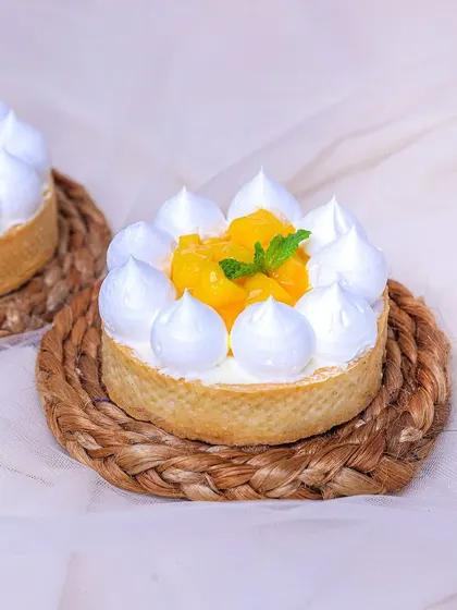 Our Mango Tart is a burst of sunshine, with a buttery pastry crust, creamy filling, and a topping of fresh mango.