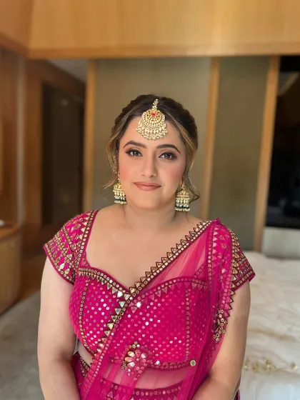 A happy bride, her makeup looking soft and natural for her Mehendi ceremony.