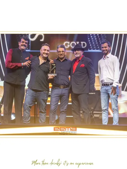 On stage receiving the Gold Award at the EEMA Spotlight Awards 2025. This recognition from the Event & Entertainment Management Association is a significant honor.