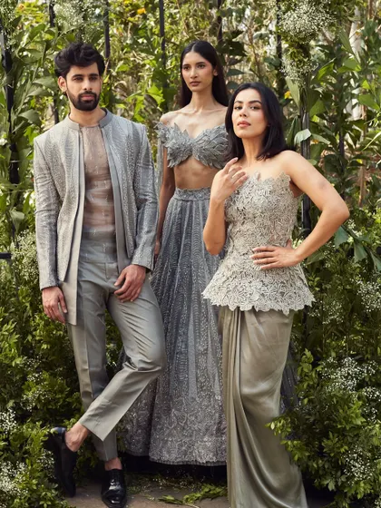 This coordinated group look in shades of grey showcases modern couture. The men's layered outfit with a sheer inner kurta is a daring and sophisticated choice for a fashion forward event.
