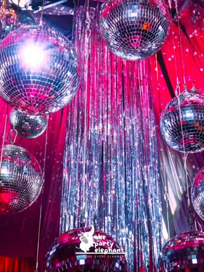 Nothing says disco like a ceiling full of shimmering disco balls. I hung these above a silver fringe curtain to create a dazzling effect of light and reflection throughout the party space.