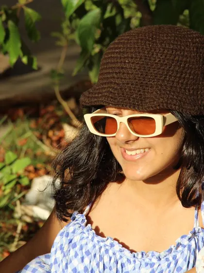 The bucket hat is a perfect accessory for a sunny day out. Here it is styled with some retro sunglasses for a complete look.
