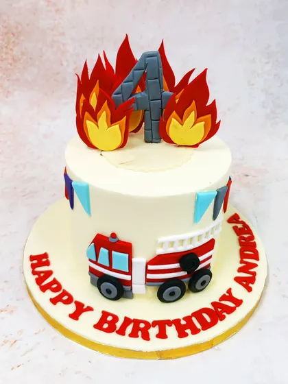 This Firetruck Cake is ablaze with excitement, featuring edible flames, a number '4' topper, and a fire engine on the side.