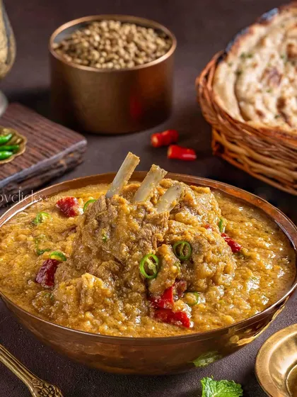A flavorful Mutton Haleem, slow-cooked with lentils and spices, garnished with green chilies and mint.