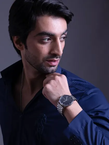 A close-up of the navy blue shirt, paired with a classic watch. This look is tailored to the finest detail, designed for your boldest moves.
