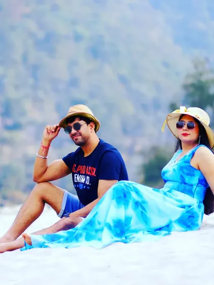 A relaxed portrait from a beach-themed pre-wedding shoot. The couple's coordinated hats and casual poses give this shot a fun, vacation-like vibe.