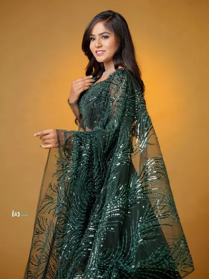 A classic and graceful pose that highlights the intricate details of the green lehenga. The subject's smile makes the portrait feel warm and inviting.