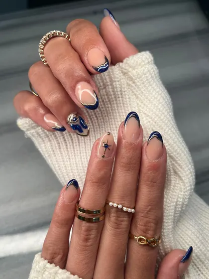 This angle highlights the different hand-painted details, including the delicate star on one nail and the abstract design on another. It's all about creating a unique story.