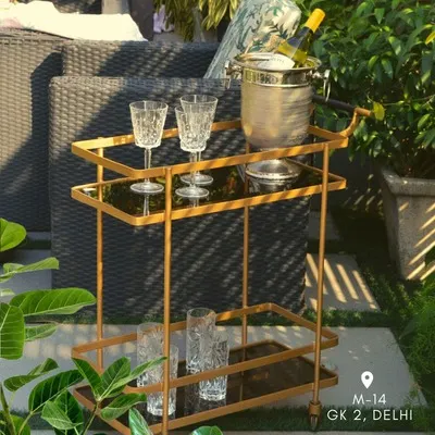 This bar trolley in a golden finish is perfect for outdoor entertaining. It has two levels to hold all your bar essentials, from glasses to an ice bucket.