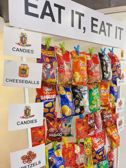 We included iconic inside jokes from the show, such as poorly labeled balloons, a "Rude that you're leaving" farewell banner, and a snack wall with the sign "Eat it, eat it".