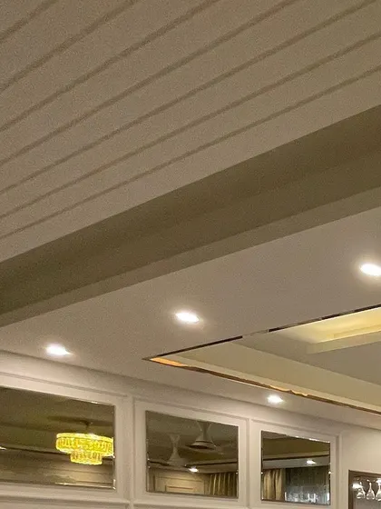 A look at the false ceiling detail, where we've used grooved panels and a brushed metal profile to add subtle texture and a modern metallic accent.