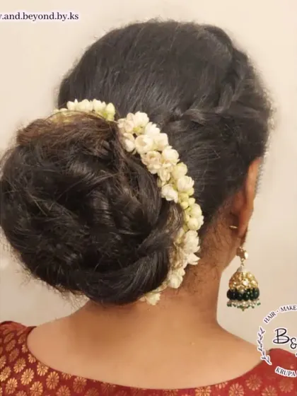 A back view of the messy bun with crown braids and gajra. This angle highlights the fullness of the bun and the delicate placement of the jasmine flowers.