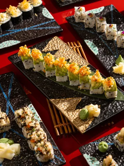A variety of sushi rolls presented on textured black plates. This image highlights our skill in composing shots with multiple elements to show the breadth of a menu.