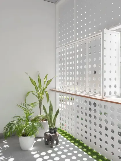 Inside the LUCID House, the perforated screen casts a dappled light effect onto the balcony floor and walls. This space becomes a canvas for the changing light, documenting the passage of time throughout the day.