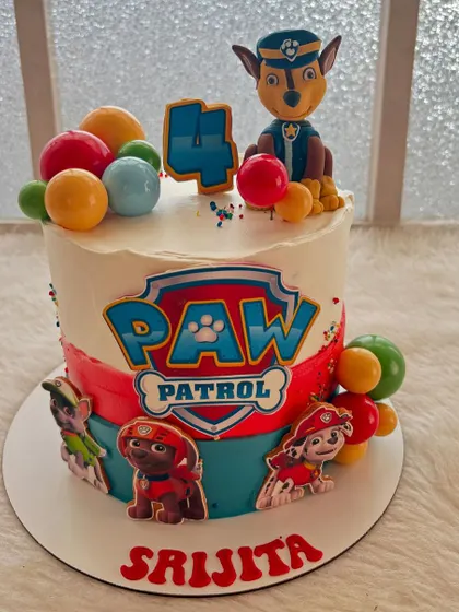 This Paw Patrol cake is on a roll! It features Chase and the gang on a colorful two-toned cake, ready for a rescue mission at a 4th birthday party.