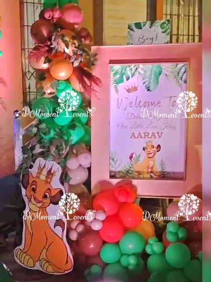 A welcome sign for "Our Little Lion King, Aarav," framed by themed balloons and a Simba cutout.
